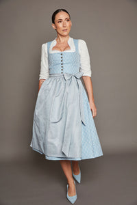 Goldhirsch Tracht, hellblaues Dirndl „Schliersee“ verbindet traditionelle Stoffe mit einem modernen, monochromen Gesamtbild.