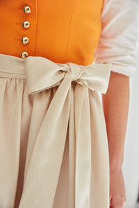 So hochwertig und verlockend wie eine sommerliche Orange aus Valencia: Das stilvolle Leinen-Dirndl aus der Charity-Kollektion GOLDHIRSCH x RETLA e.V. ist inspiriert von bayerischer Tradition und einem Hauch italienischem Sommerflair.