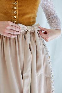 oniggelb – eine Farbe, die aus der Tradition kommt und trotzdem nicht alltäglich ist. Genau richtig für alle, die Lust auf ein Dirndl haben, das nicht jede trägt.