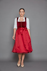Das Must-have-Dirndl der Saison! Mit edlem, dunkelrotem Baumwollsamt und einheitlichem Rock und Schürze ist das Dirndl „Vienna“ so verführerisch und stilvoll wie ein Glas Bordeaux in der Abendsonne.