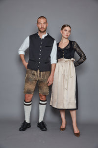 Die markante Weste aus der Goldhirsch X RETLA e.V. Kollektion überzeugt mit dezent gemustertem Schwarz und edlen Samtdetails an Kragen und Taschen.